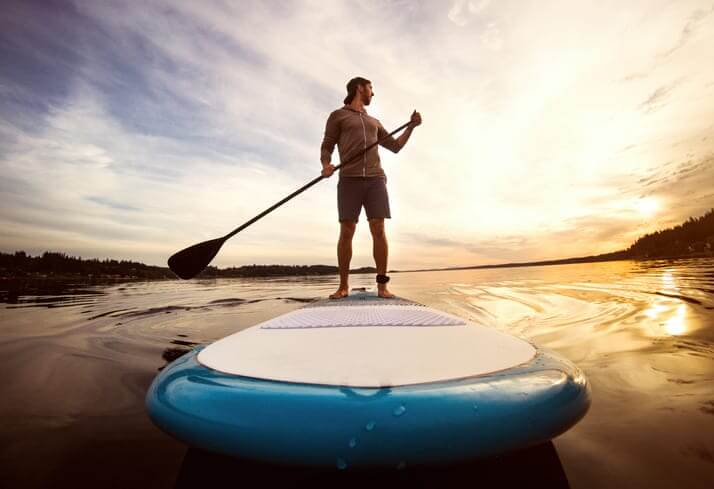Man Riding Paddleboard on Puget Sound At Sunset